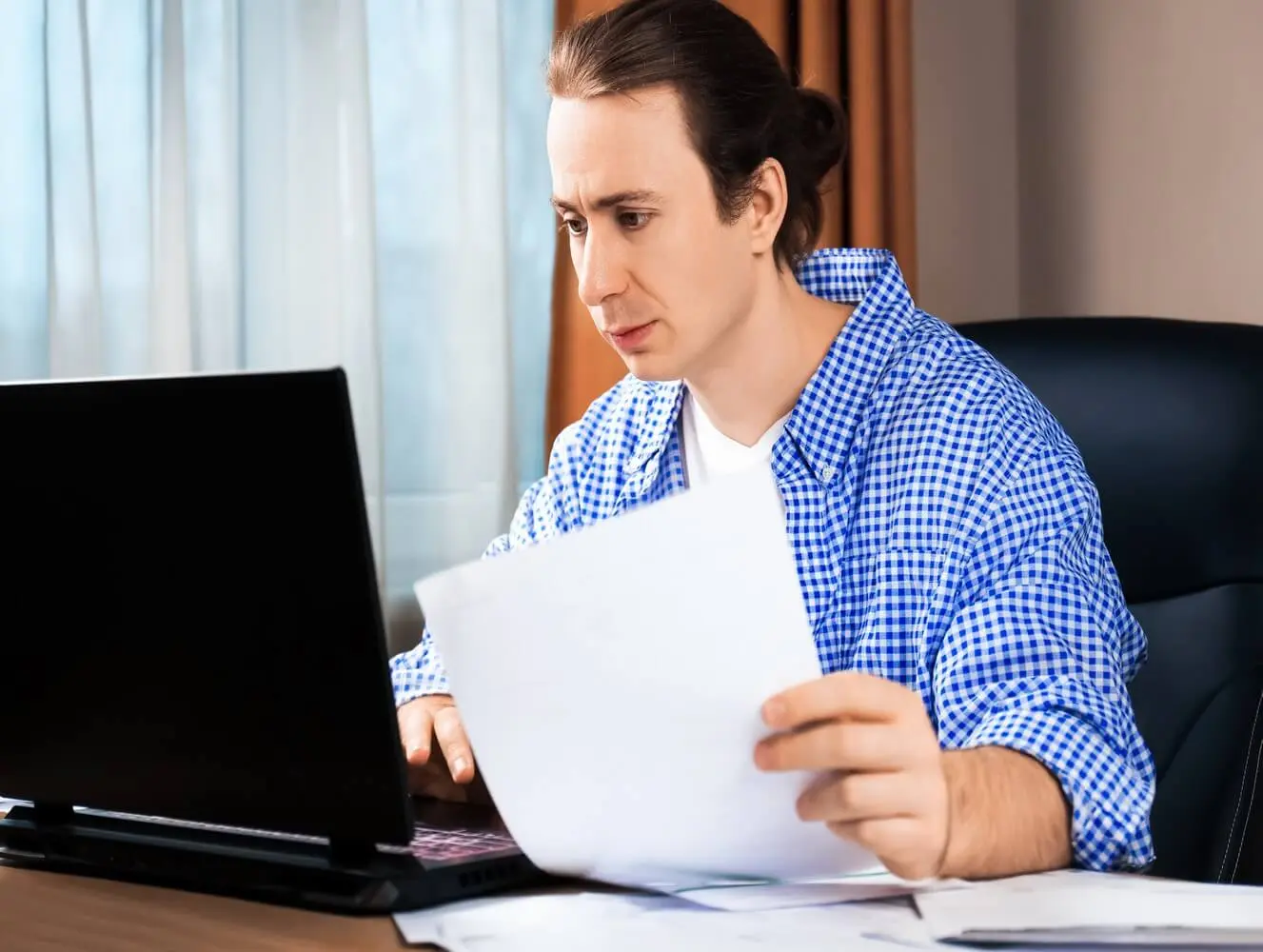 personne consultant des documents administratifs sur ordinateur